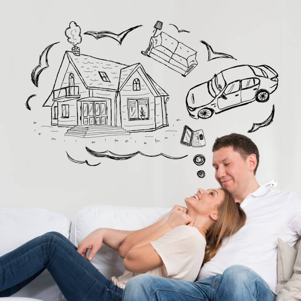 Couple sitting on a sofa with a bubble containing their goals in buying a home, a new car, and new furniture